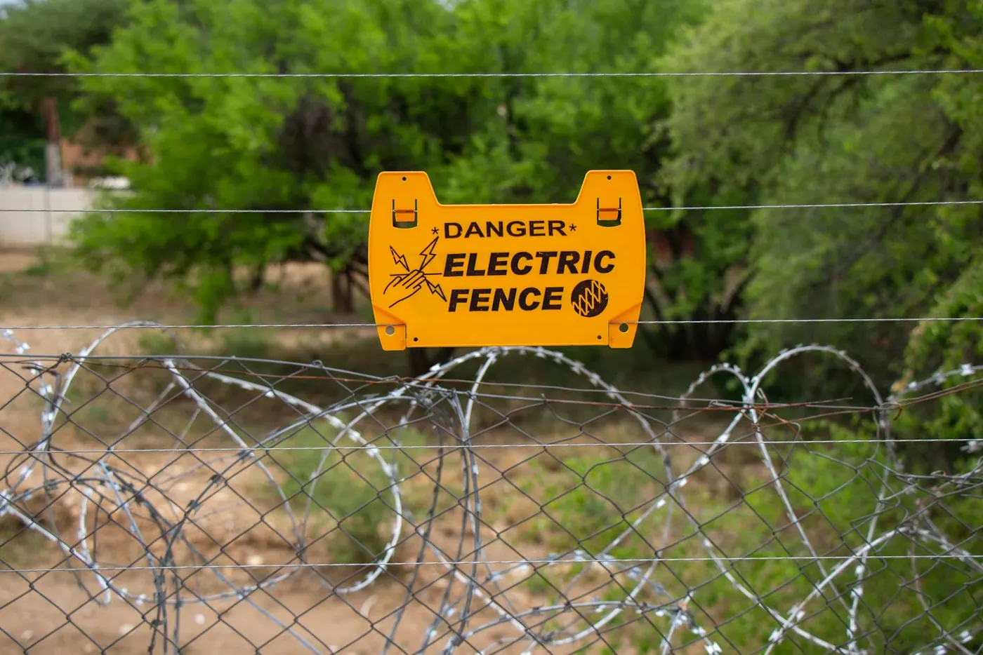 Danger sign on an electric fence with razor wire